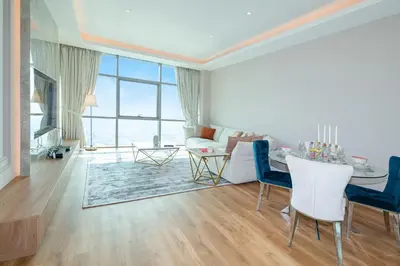 a living room with a table and blue chairs at Upgraded 1BR on a high floor of Liberty House,DIFC - Allsopp&Allsopp in Dubai