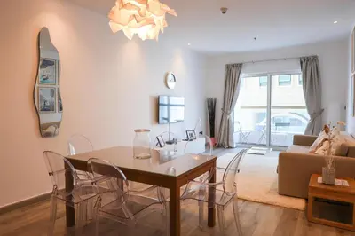 a living room with a table and chairs and a couch at Deluxe 1 Bedroom Apartment - Elite Residence Dubai Marina - Sea View in Dubai