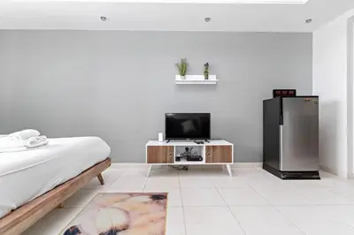 a bedroom with a refrigerator and a tv in it at StoneTree - Near Metro - Furnished Studio in JLT in Dubai