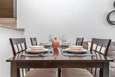a wooden table with chairs and plates and a vase at StoneTree - Near Metro - Furnished Studio in JLT in Dubai