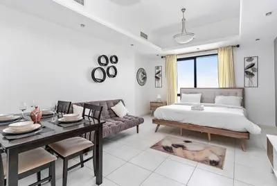 a bedroom with a bed and a table and a couch at StoneTree - Near Metro - Furnished Studio in JLT in Dubai