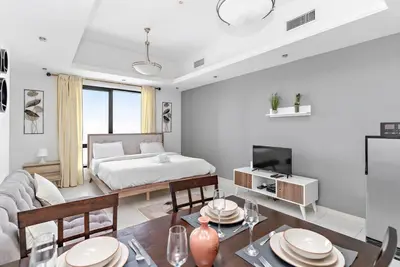 a living room with a bed and a table at StoneTree - Near Metro - Furnished Studio in JLT in Dubai