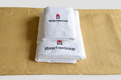 a towel with the words stone tree group on it at StoneTree - Elegant 2BR with 1 Maids Room in Dubai