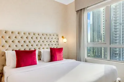 a bedroom with a large white bed with red pillows at Durrani Homes - Grandiose 5BR Besides Dubai Mall with Burjkhalifa and Fountain view in Dubai