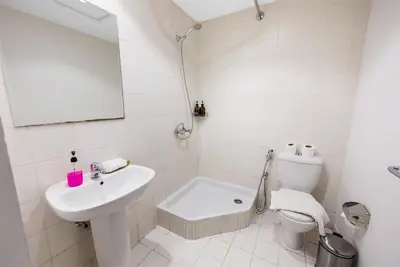 a white bathroom with a sink and a toilet at Durrani Homes - Grandiose 5BR Besides Dubai Mall with Burjkhalifa and Fountain view in Dubai