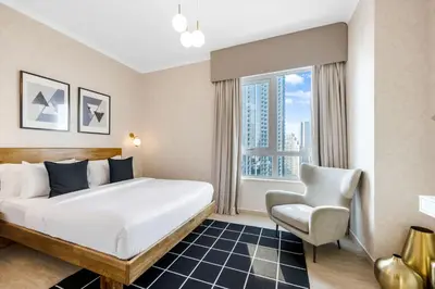 a hotel room with a bed and a chair at Durrani Homes - Grandiose 5BR Besides Dubai Mall with Burjkhalifa and Fountain view in Dubai
