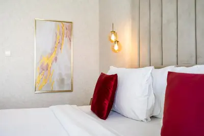 a bedroom with a white bed with red pillows at Durrani Homes - Lavish 3BR Besides Burj Khalifa and Fountain view in Dubai