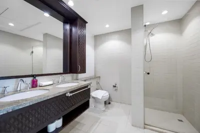 a bathroom with two sinks and a toilet and a shower at Durrani Homes - Lavish 3BR Besides Burj Khalifa and Fountain view in Dubai