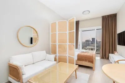 a living room with a couch and a table at Bloom Heights: Pool, Gym & Wi-Fi - JVC - Dubai in Dubai