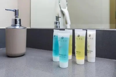 a row of five shampoo bottles on a counter at Bloom Heights: Pool, Gym & Wi-Fi - JVC - Dubai in Dubai