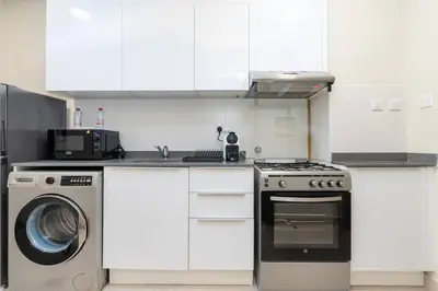 a kitchen with a washing machine and a washer at Bloom Heights: Pool, Gym & Wi-Fi - JVC - Dubai in Dubai