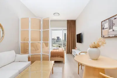 a living room with a couch and a table at Bloom Heights: Pool, Gym & Wi-Fi - JVC - Dubai in Dubai