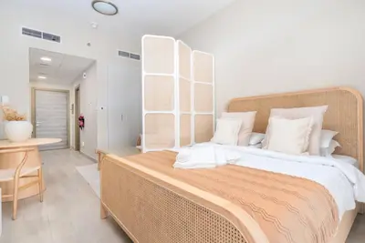 a bedroom with a large bed with white pillows at Bloom Heights: Pool, Gym & Wi-Fi - JVC - Dubai in Dubai