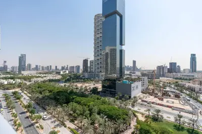 an aerial view of a city with a tall skyscraper at Bloom Heights: Pool, Gym & Wi-Fi - JVC - Dubai in Dubai