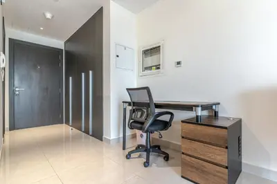 an office with a desk and a chair and a cabinet at Bright & Elegant Studio Balcony Speedy Wi-Fi in Dubai