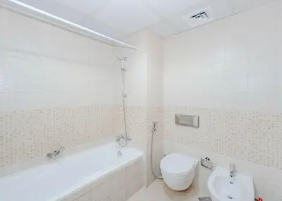 a bathroom with a tub and a toilet and a sink at StoneTree - Spacious 1BR - Best Location for Tourist in Dubai