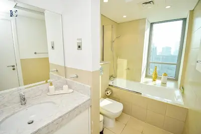 a bathroom with a sink and a toilet and a window at Luxury Escapes - Newly furnished 1BR Apartment - 8 BLVD WALK DOWNTOWN in Dubai