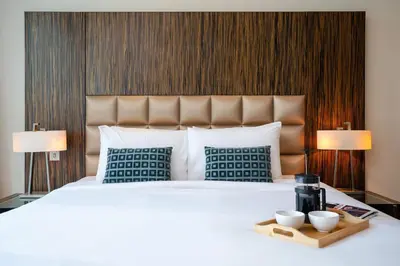 a bedroom with a white bed with two cups on a tray at Lovely Lake View - Two Bedroom - JLT in Dubai