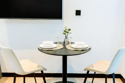 a table with two chairs and a table with plates and glasses at Cozy Studio whit balcony 15NS in Dubai