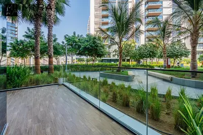 a courtyard with palm trees in a building at Mira Holiday Homes - Serviced 1 bedroom in Bluewaters in Dubai