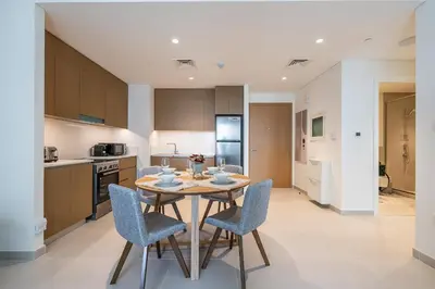 a kitchen and dining room with a table and chairs at Modern 1 Bedroom Apartment I Creek Beach I Surf in Dubai