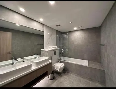 a bathroom with two sinks and a tub and a toilet at Mira Holiday Homes - Serviced 2 bedroom in Dubai Marina in Dubai