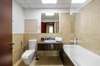a bathroom with a tub and a toilet and a sink at Amazing 1BR With Sea View Rimal 4 JBR - NOX Holiday Homes in Dubai