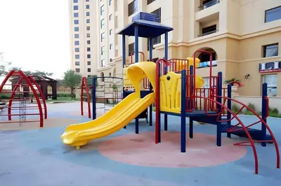 a playground in front of a building with a slide at Amazing 1BR With Sea View Rimal 4 JBR - NOX Holiday Homes in Dubai