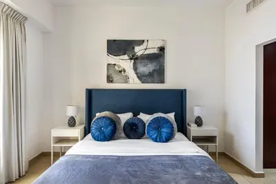 a bedroom with a large bed with blue pillows at Amazing 1BR With Sea View Rimal 4 JBR - NOX Holiday Homes in Dubai