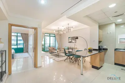 a kitchen and living room with a table and chairs at Dazzling 1BR at Marina Crown Dubai Marina by Deluxe Holiday Homes in Dubai