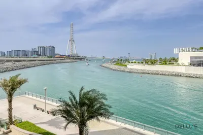 a river with palm trees next to a city at Sleek 1BR at 5242 Tower 1 Dubai Marina by Deluxe Holiday Homes in Dubai