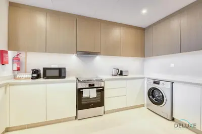 a kitchen with white cabinets and a washer and dryer at Sleek 1BR at 5242 Tower 1 Dubai Marina by Deluxe Holiday Homes in Dubai