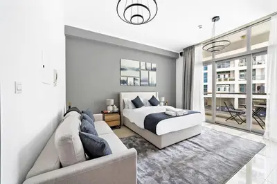 a white bedroom with a bed and a couch at StoneTree - Cozy Studio in DEC Tower - Dubai Marina in Dubai
