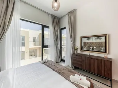 a bedroom with a large bed and a large window at StoneTree - 3 BR with 1 Maids Room Villa in Camelia - Arabian Ranches in Dubai