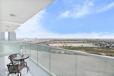a balcony with a table and a view of the city at StoneTree - Stylish Studio Apartment in Damac Hills in Dubai
