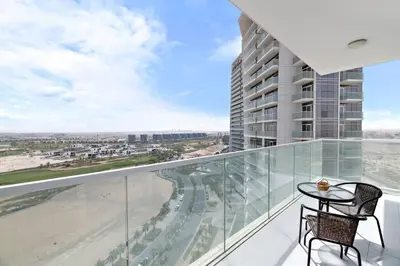 a balcony with a table and a view of the beach at StoneTree - Stylish Studio Apartment in Damac Hills in Dubai