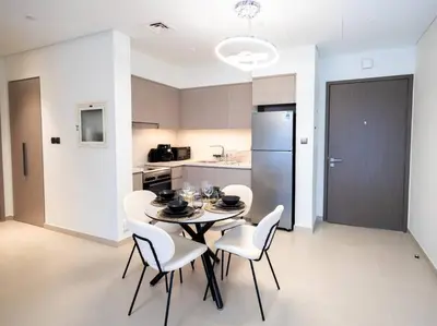 a dining room with a table and chairs in a kitchen at MH - Act One Act Two - DownTown - 1BHK - REF505 in Dubai