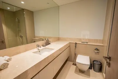 a bathroom with a sink and a toilet and a mirror at MH - ACT Tower -Downtown- 2Bedrooms - REF 408 in Dubai