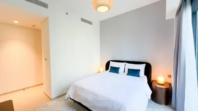 a bedroom with a white bed with two blue pillows at MH - ACT Tower -Downtown- 2Bedrooms - REF 408 in Dubai