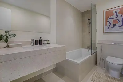 a bathroom with a sink and a toilet and a bath tub at Brand New Luxurious 4BR & Maid Room Townhouse in Dubail Hill Estate in Dubai