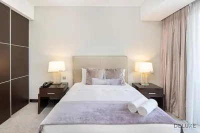a bedroom with a large bed with two night stands at Marina Canal Views 2BR Unit Next to Marina Mall, The Address Residences, Dubai Marina by Deluxe Holiday Homes in Dubai