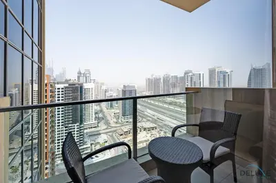 a balcony with chairs and a view of a city at Marina Canal Views 2BR Unit Next to Marina Mall, The Address Residences, Dubai Marina by Deluxe Holiday Homes in Dubai