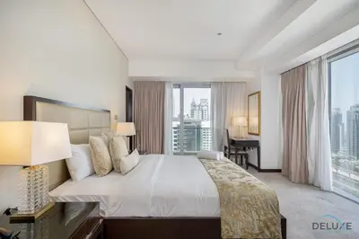 a hotel room with a large bed and a desk at Marina Canal Views 2BR Unit Next to Marina Mall, The Address Residences, Dubai Marina by Deluxe Holiday Homes in Dubai
