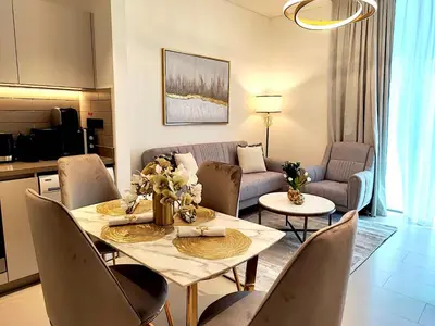 a living room with a table and a couch at New 1 bedroom in Sobha - Community View in Dubai