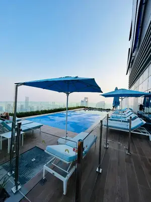 a pool on the roof of a building with umbrellas at Unique 2br with Infinity Pool view on Burj Khalifa in Dubai