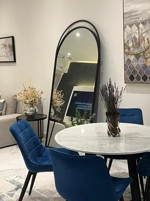 a dining room with a table and chairs and a mirror at 8 Boulevard Walk 'Heart of Downtown' in Dubai