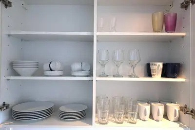a shelf with plates and wine glasses and dishes at Deluxe - Amazing views - Elite in Dubai