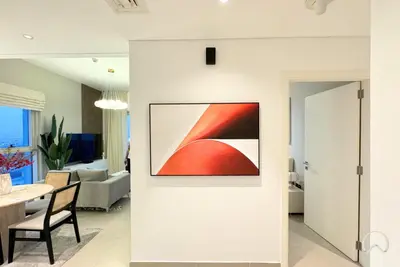 a living room with a painting on the wall at Oraya - Apt. With Skyline and Garden View Along With City in Dubai