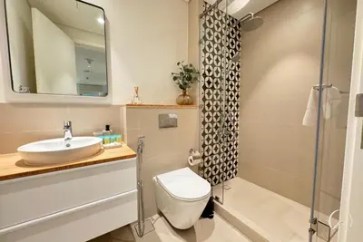 a bathroom with a sink and a toilet and a shower at Oraya - Apt. With Skyline and Garden View Along With City in Dubai