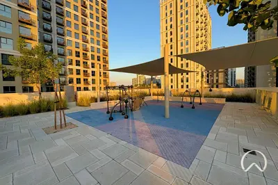 a playground in a city with tall buildings at Oraya - Apt. With Skyline and Garden View Along With City in Dubai